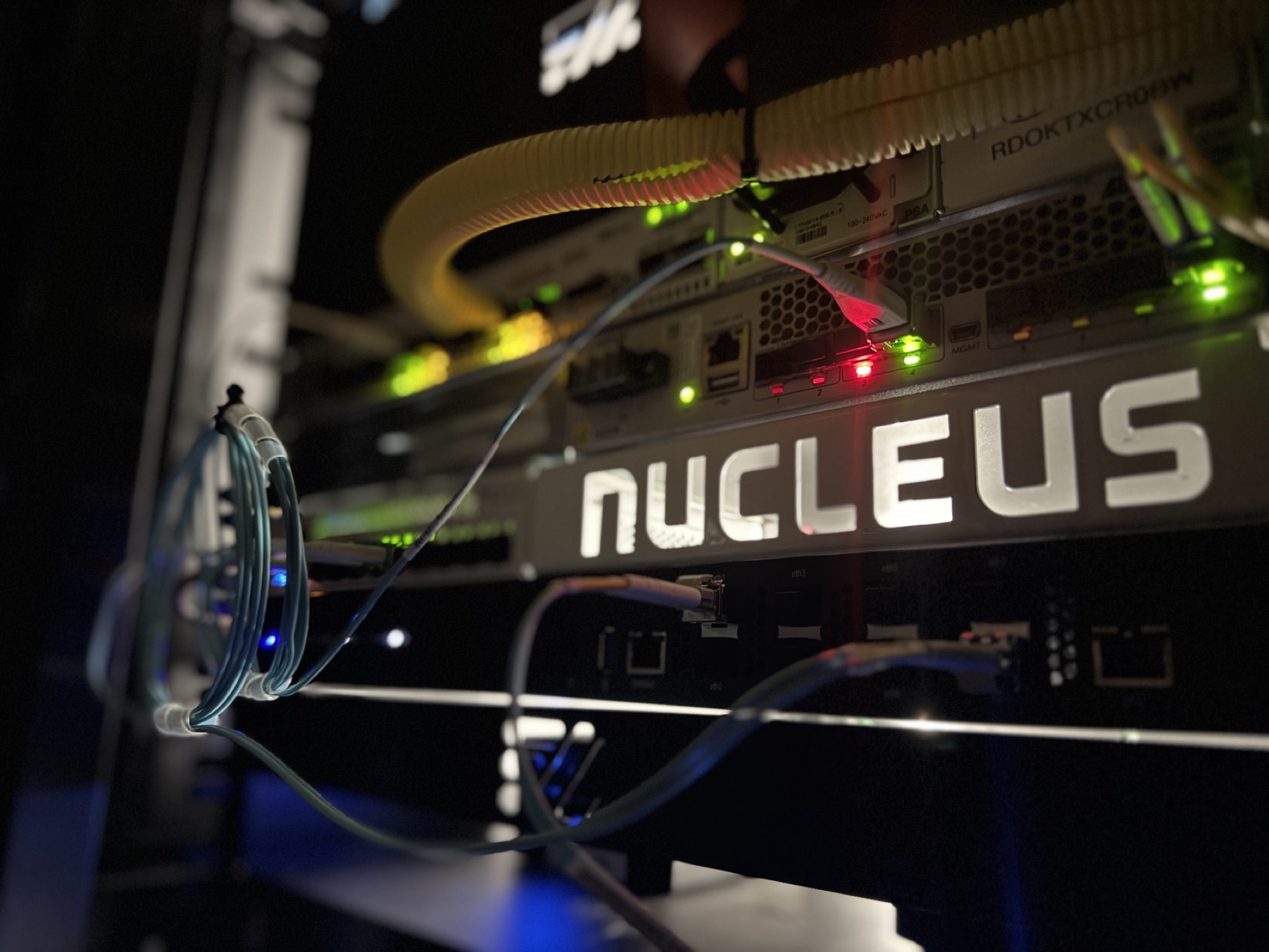 Nucleus customer premises equipment installed in a network rack with live status lights and fiber jumpers